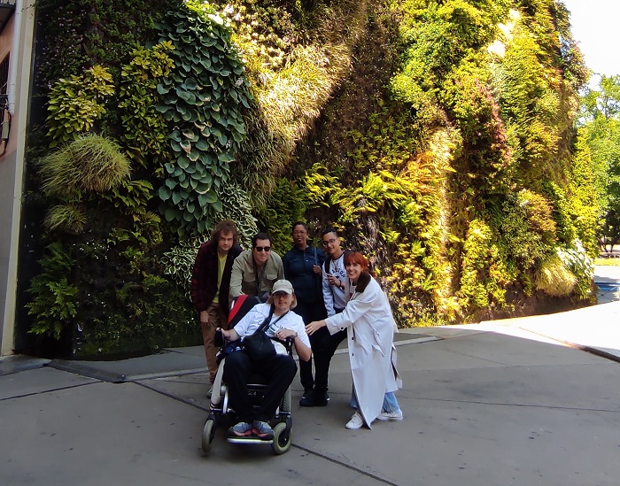 Personas usuarias y personal del centro ante el jardín vertical